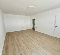 Empty bright interior of a 2-room apartment with wooden flooring and white walls.