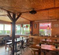 Interior of dining spaces with tables, wooden paneling, and decorative lights.