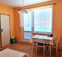 Interior of a 2-room apartment with a dining table, chairs, and a large window.