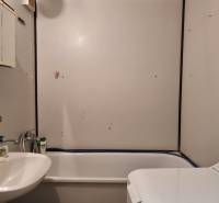 Bathroom in a 2-room apartment with a bathtub, sink, and washing machine.