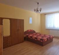 Bedroom in a 2-room apartment with a bed, wardrobe, and yellow walls.