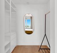 Interior of a 2-room apartment with a mirror, shelves, and a clothes rack.