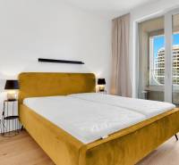 Bedroom in a 2-room apartment with a bed and a balcony.