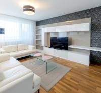 Living room in a 3-room apartment with a white sofa and decorative wallpaper.