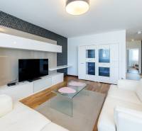Living room in a 3-room apartment with white furniture and a TV on the wall.