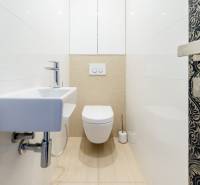 Bathroom in a 3-room apartment with a toilet, sink, and decorative doors.