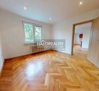 A room in a 3-room apartment with a patterned floor and open doors.