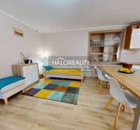 Modern interior of a family house with a dining table and a colorful carpet.