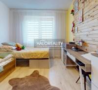 Children's room in a family house with a wooden wall, bed, and desk.