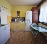 A kitchen in a family house with wooden cabinets and a dining table.