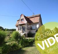 A family house in Topoľčianky with traditional architecture, surrounded by greenery and a lawn.