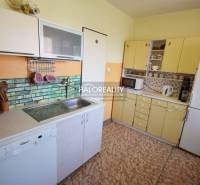 A kitchen in a family house with a refrigerator, dishwasher, and cabinets.