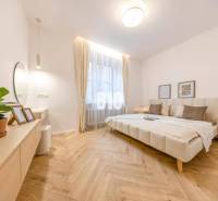 A bright bedroom with a mirror, a plant, and a comfortable bed in a 3-room apartment.