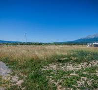 Residential plots in Mlynica surrounded by mountains and blue skies.