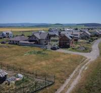 Residential plots in Mlynica with family houses and rural landscape in the background.