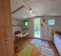 The interior of the cabin is furnished with a wooden table and colorful decorations on the windows.