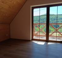 Attic of a cottage with wooden walls, view from the window to nature.