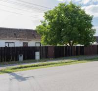 A building with an old roof on Športová Street in Gajary, surrounded by a fence. Land - residential.