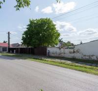 Športová Street in Gajary with residential plots, next to the road and trees.