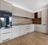 A kitchen in a 3-room apartment with wooden flooring and built-in appliances.