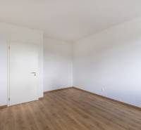 Empty room with white walls and wooden floor, suitable for a 3-room apartment.