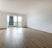 Spacious living room in a 3-room apartment with a view through a large window.