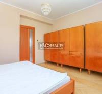 A bedroom in a 3-room apartment with a built-in wardrobe and wooden furniture.