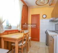 A kitchen in a 3-room apartment with a wooden table and chairs.