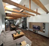 A large living space in a family house with wooden ceiling beams and a comfortable sofa.