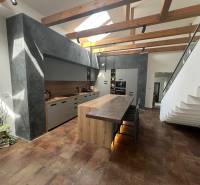 A kitchen in a family house with wooden beams and a modern kitchen island.