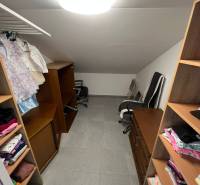 A wardrobe in a family house with shelves, a chair, and hanging clothes.