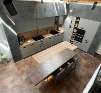 A kitchen in a family house with an island, gray cabinets, and wooden accents.