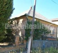 A family house in Rúbaň with an older exterior, surrounded by a fence and vegetation.