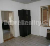 A simple interior in a family house with wooden flooring and a dark wardrobe.
