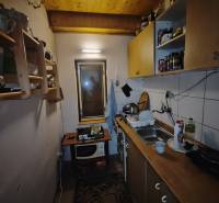 Cozy kitchen in a cabin with a wooden ceiling and standard equipment.