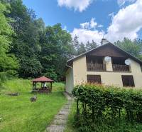 The cottage on Dobra in Kvakovce, surrounded by greenery, near the forest and the gazebo.