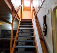 A staircase in a cottage with wooden decor and decorative elements on the walls.