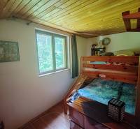 Bunk bed in the interior of a cabin with a wooden ceiling.
