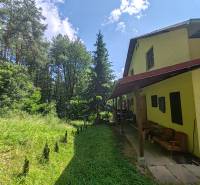 The cottage on Dobra in Kvakovce is surrounded by greenery and a forest environment.
