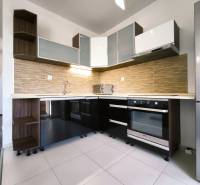 A kitchen in a 2-room apartment with a modern unit, appliances, and storage space.