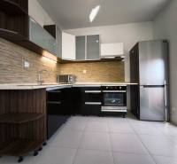 A kitchen in a 2-room apartment with modern equipment and a corner cabinet set.