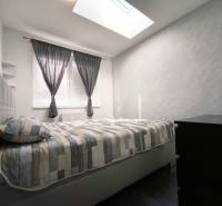 A bright bedroom with a double bed and a dresser in a 2-room apartment.