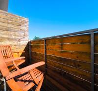 A balcony with wooden chairs and a railing in a 2-room apartment.