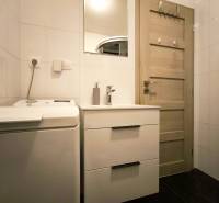 Bathroom with a washing machine, wardrobe, and mirror in a 2-room apartment.