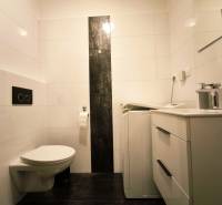 Bathroom in a 2-room apartment with a washing machine, sink, and toilet.