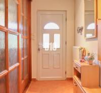 A hallway with wooden furniture and doors in a family house.