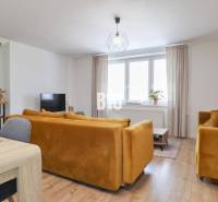 Living room in a family house with yellow sofas and a dining table.
