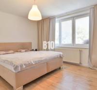 Bedroom in a family house with a large bed and minimalist furniture.