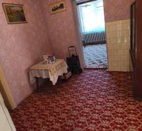 Interior of a family house with carpet, wallpaper, and furniture, including a painting on the wall.