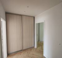 Interior of a 2-room apartment with a built-in wardrobe and light parquet flooring.